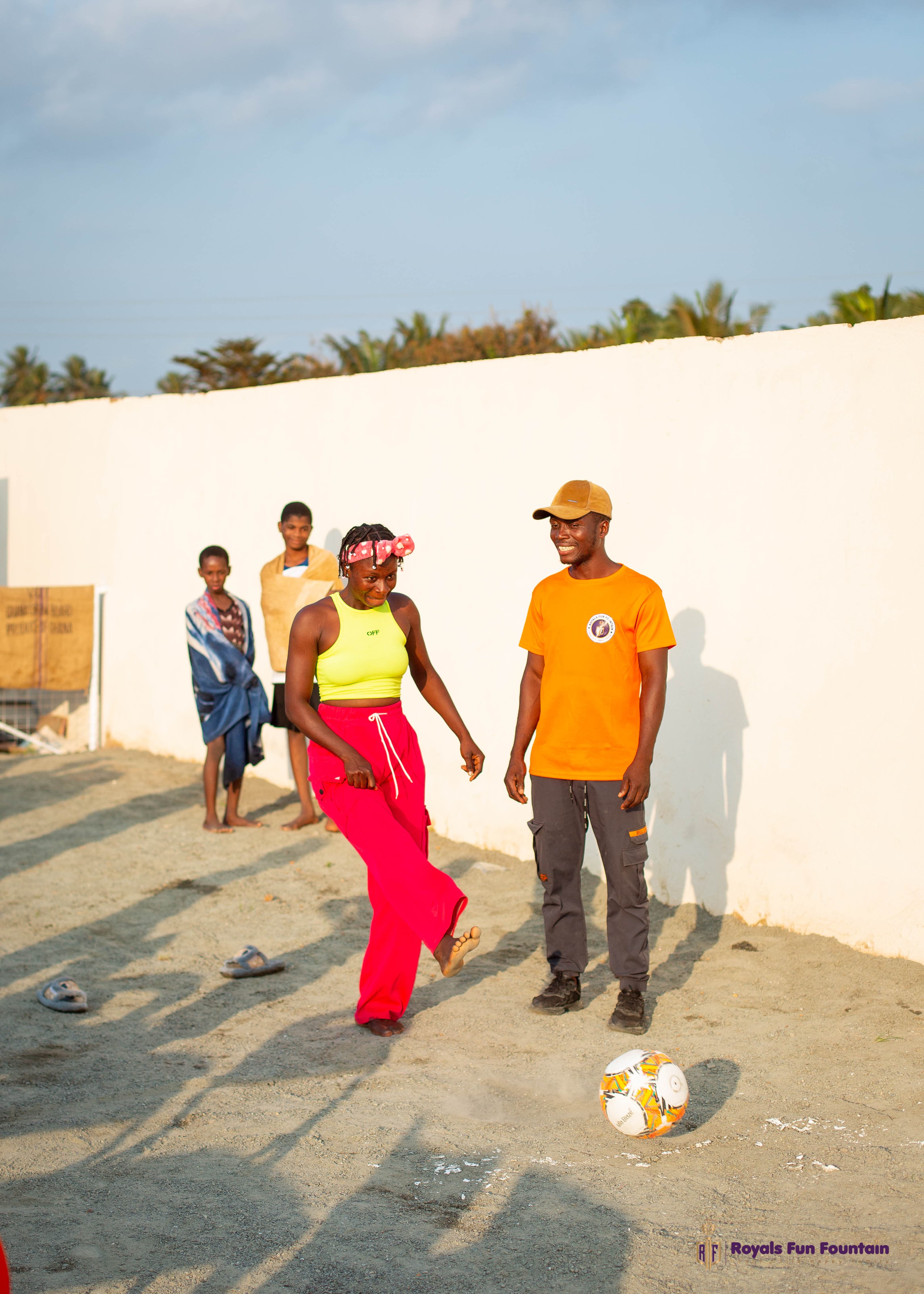 A woman kicking a football during a family games day