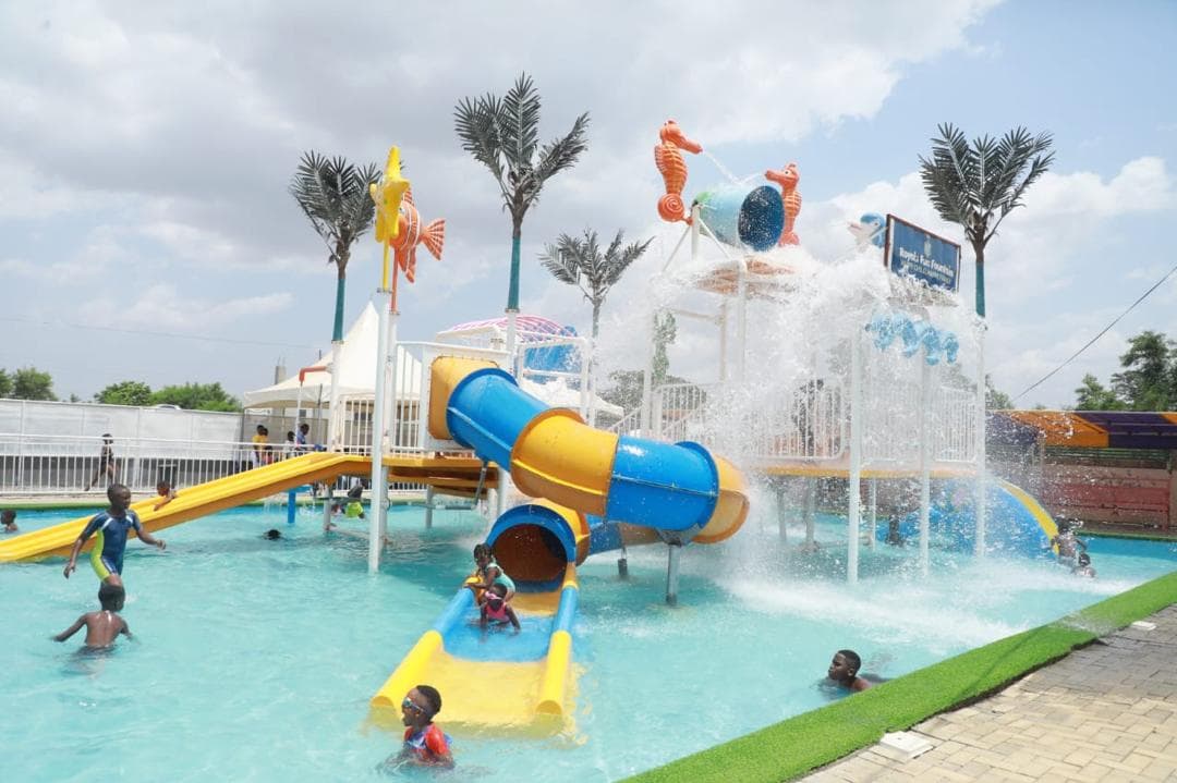 Children playing on the yellow and blue slides of the waterpark
