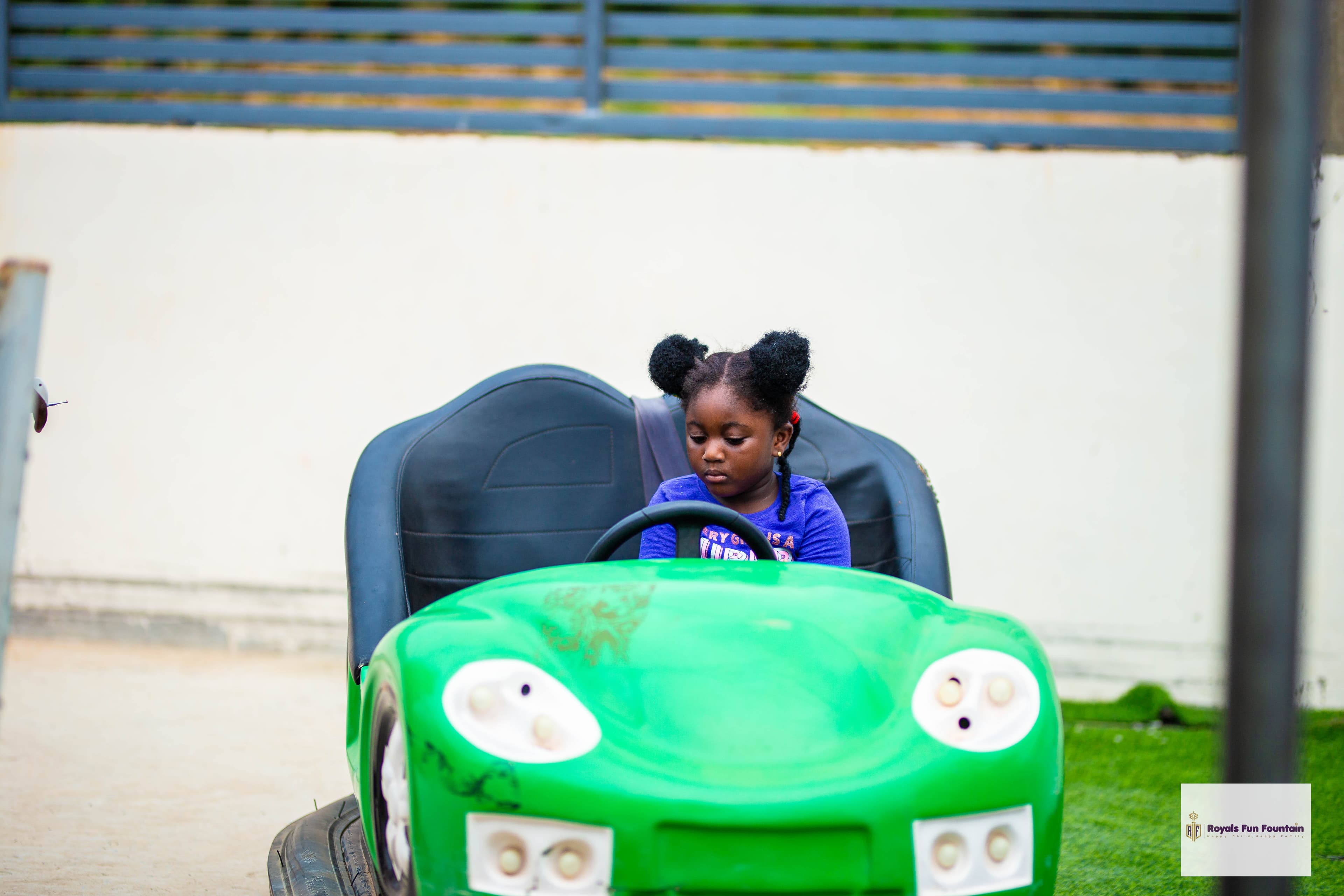 A girl driving a green bumper car