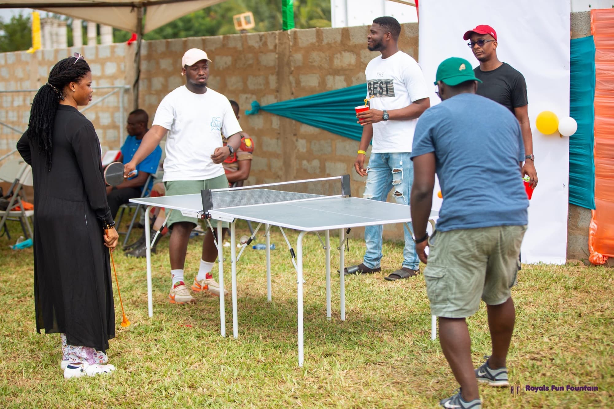 Friends playing table tennis on the lawn at an event